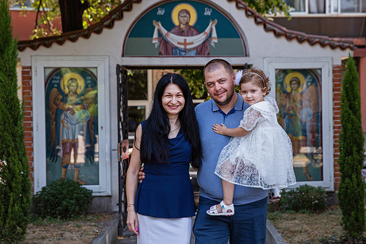 Семейство с детето си застанали за снимка след кръщене в двора на храм "Св. Петка", Пловдив.