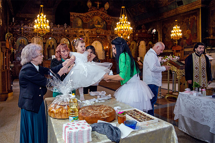 Преобличане на момиченце с новата му бяла рокля по време на ритуал Свето Кръщение в Храм "Св. Възнесение Господне" в Пловдив.