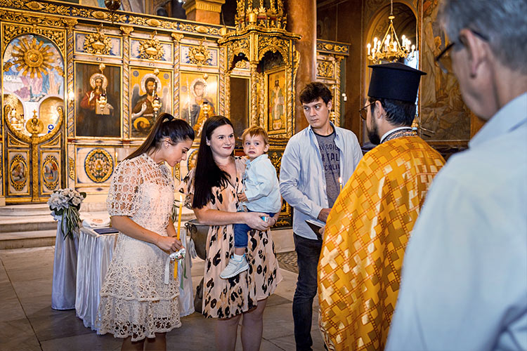 Кръстницата на момченцето заплюва сатаната по време на ритуал Свето Кръщение в катедрален храм Света Богородица, град Пловдив.