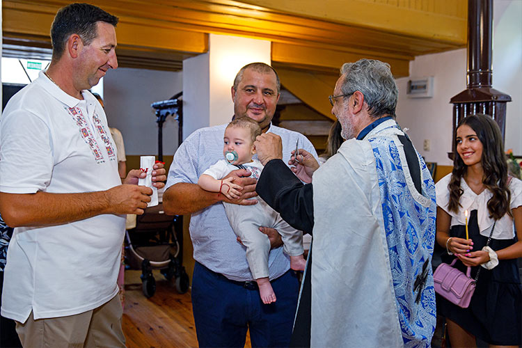 Отецът отрязва кичур коса от новопокръстено момченце по време на ритуал Свето Кръщение в храм "Свети Свети Контантин и Елена", село Браниполе.