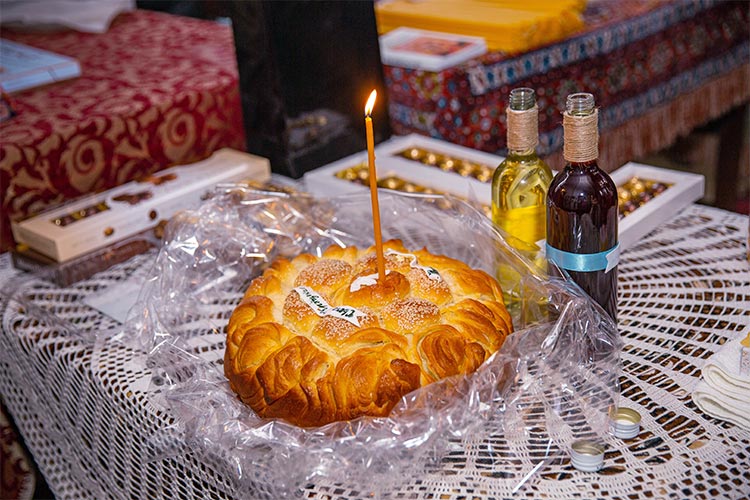 Освещаване на ритуална пита за почерпка на гостите в храма след края на кръщението в храм Света Троица, град Стамболийски.