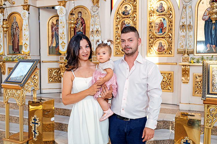 Майка и баща с новопокръстеното си момиченце след края на кръщението му в храм Свети Николай Мирликийски Чудотворец, град Пловдив.
